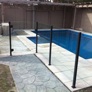 Backyard swimming pool with black safety fence