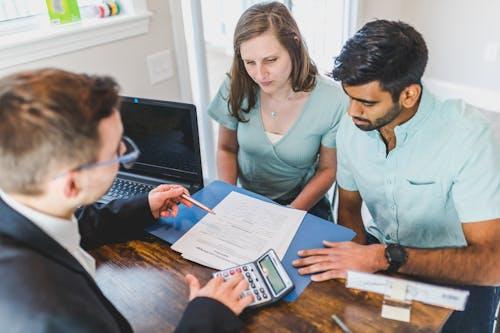 Couple meeting financial advisor reviewing documents